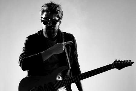 Male musician with guitar music rock star light backgroundの写真素材