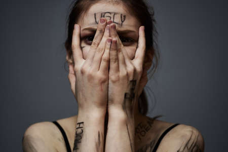 woman with offensive inscriptions on her body touching herself with hands stress frustration hate