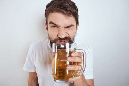 emotional man with a large mug of beer alcoholic drink gesturing with his hands drunken stateの写真素材