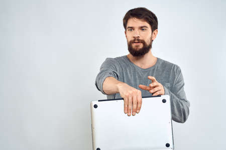 Emotional man holding a laptop success modern style work light backgroundの写真素材