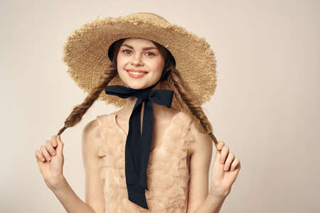 romantic girl in beige dress and in straw hat with black ribbon emotions portrait of model cropped viewの写真素材