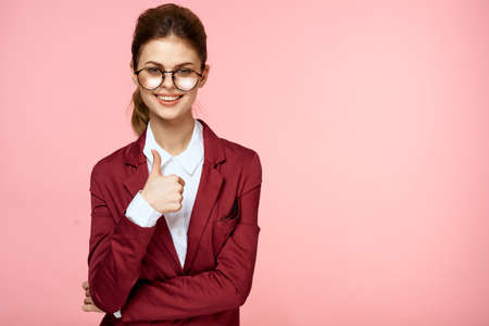 Business woman red jacket glasses executive lifestyle studio pink backgroundの写真素材