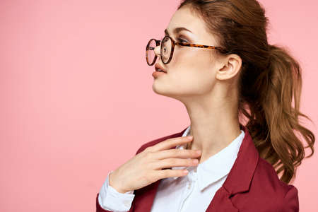 Elegant woman in red jacket glasses office manager pink backgroundの写真素材