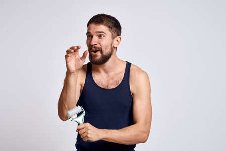 man with a massager in his hand and in a blue t-shirt spa treatments hygiene clean skin emotions modelの写真素材