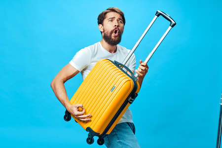 An emotional man holds in his hand a suitcase in the form of a guitarの写真素材