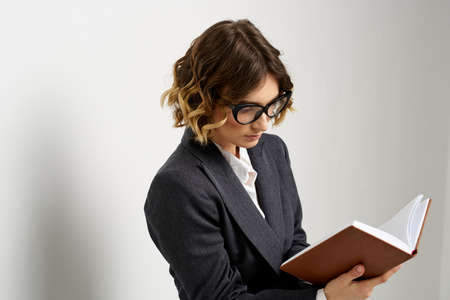 Business woman in a classic suit with a notebook in her hand and glasses on her face Copy Space