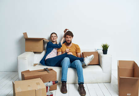 Cheerful young couple in an apartment boxes with things moving