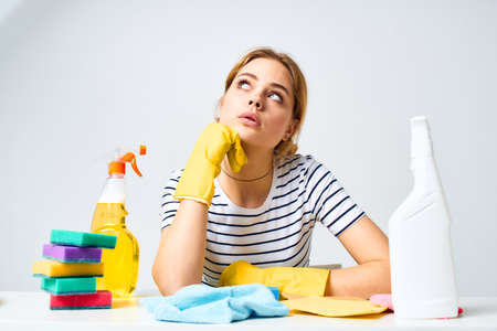 The cleaning lady sits at the table detergent work serviceの写真素材