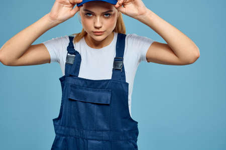 Woman in work uniform blue cap carriage delivery service courier blue backgroundの写真素材