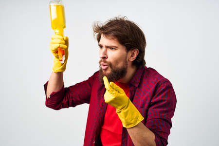 emotional man wearing rubber gloves detergent cleaning housework cropped viewの写真素材