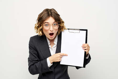 Business woman with a folder of documents on a light background cropped view and shirt suit