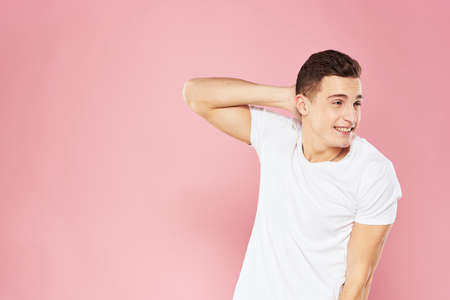 Emotional man gesturing with his hands white t-shirt pink isolated background