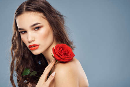 woman with a rose in her hands naked shoulders evening makeup red lipsの写真素材