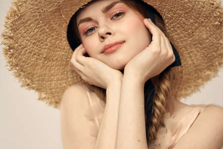 Nice girl in a straw hat with a black ribbon and in a dress on a light background romance model fun emotionの写真素材