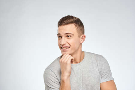 man in gray t-shirt emotions light background cropped view