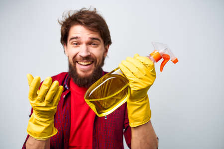 Man in yellow gloves detergent cleaning professional cropped view of housework lifestyle