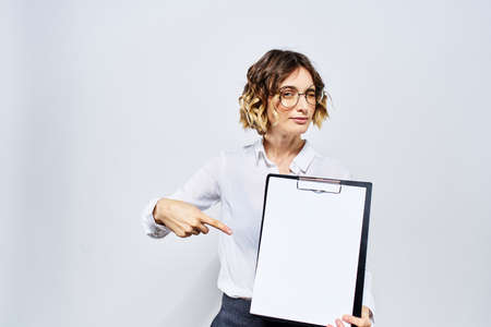 Business woman with a folder of white documents in her hand on a light background And hairstyle glasses modelの写真素材