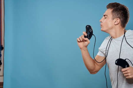 Man with joysticks wires technology games entertainment leisure fun blue backgroundの写真素材