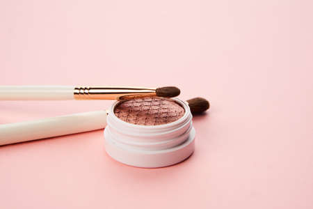 makeup brushes and eyeshadow professional cosmetics on pink backgroundの写真素材