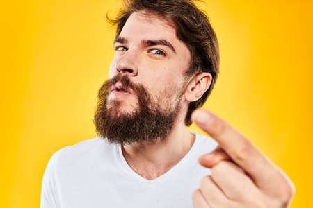 bearded man gesturing with hands studio lifestyle discontent yellow backgroundの写真素材