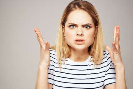 Emotional blonde woman in striped t-shirt lifestyle facial expression close-up