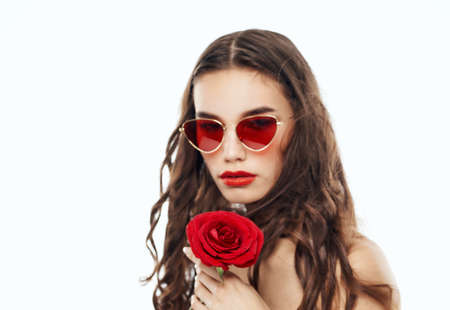 Cropped view of sexy brunette in glasses with red flower in her hands