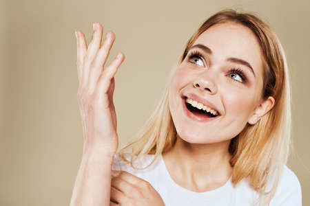 Pretty woman fun white t-shirt emotions beige background cropped view