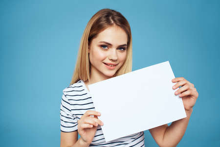 woman holding a sheet of paper in blue background.