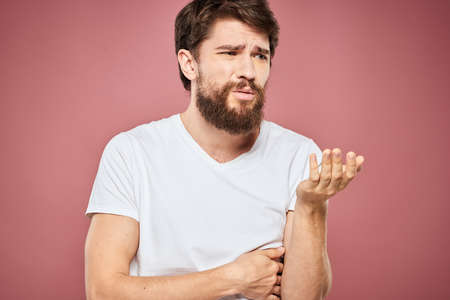 emotional man white t shirt sad facial expression pink background