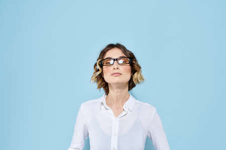 Business woman on a blue background glasses with dark rims curly hair Light shirt cropped view