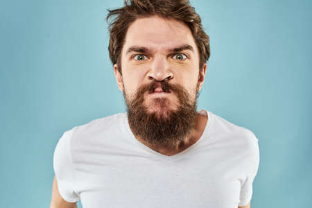 Man with disgruntled facial expression gesturing with hands studio lifestyle blue backgroundの写真素材