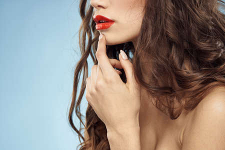 Beautiful woman naked shoulders hairstyle care bright makeup blue backgroundの写真素材