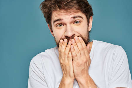 emotional man gesturing with hands lifestyle fun white t-shirt blue isolated stockの写真素材
