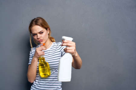 Woman striped t-shirt detergent cleaning housework gray backgroundの写真素材
