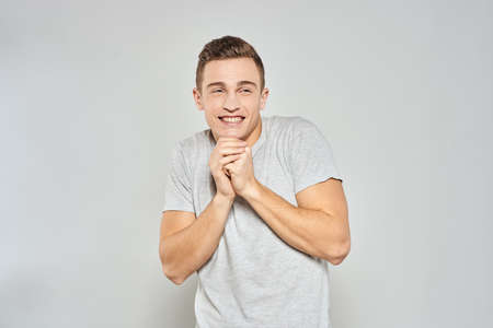 handsome man in light t-shirt cropped view emotion studio isolated backgroundの写真素材