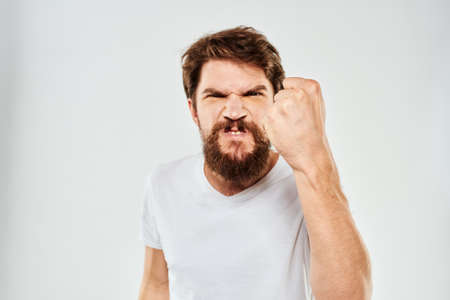 emotional man with a beard gesturing with his hands close-up studio aggression