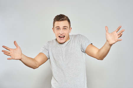 handsome man in light t-shirt cropped view emotion studio isolated background