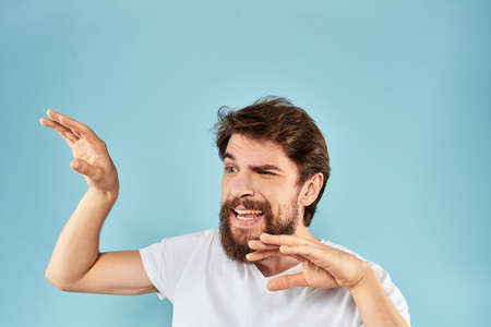 Emotional man with a beard in a white t-shirt blue background fun lifestyle