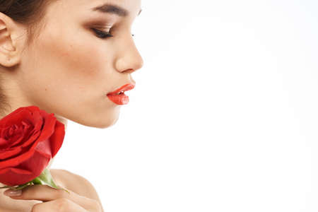 Beautiful woman with red rose near face makeup naked shoulders portrait