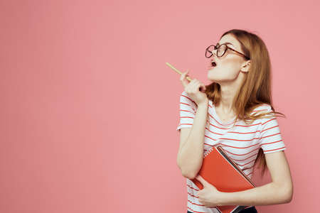 beautiful female student holding books education institute gesturing with hands pink background Copy Spaceの写真素材