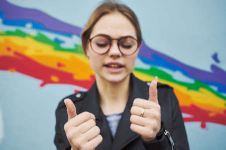 the artist with glasses near the multi-colored graffiti on the wallの写真素材