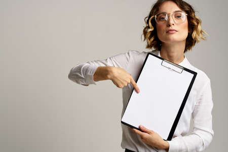 Business woman with folder of documents in hands on gray background cropped view of workの写真素材