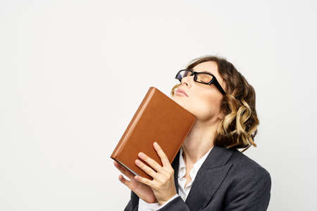 Business woman with notepad and glasses work light background cropped view of suit model.
