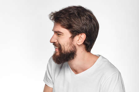 cheerful emotional bearded man gesturing with his hands close-up light background