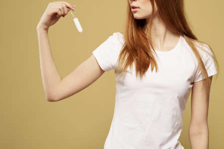 Girl with a tampon in her hand the size of the appearance of the critical days of menstruation