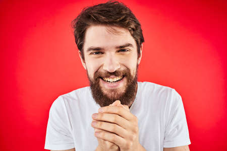 Bearded man fun emotions lifestyle cropped view white t-shirt red backgroundの写真素材