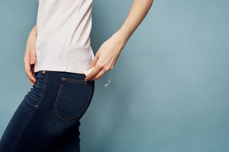 Woman with tampon and jeans t-shirt menstruation blue background cropped view hygieneの写真素材