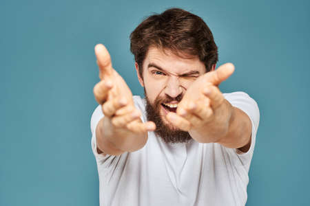 emotional man gesturing with hands lifestyle fun white t-shirt blue isolated stockの写真素材