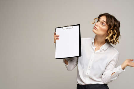 Business woman with folder of documents in hands on gray background cropped view of workの写真素材