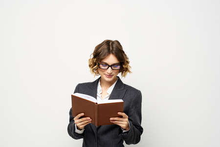 Business woman with notepad and glasses work light background cropped view of suit model.